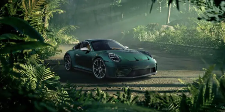یک پورشه 911 GT3 زوندروونش سبز رنگ خیرهکننده در جادهای خاکی پارک شده و پوشش گیاهی انبوه و سرسبز جنگل آن را احاطه کرده است، در حالی که نور خورشید از لابهلای درختان میتابد.