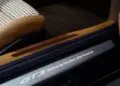 نمایی نزدیک از فضای داخلی یک پورشه با چرم قهوهای و صندلی با طرح پارچه شطرنجی، که روی رکاب در آن عبارت «GT3 25 سال پورشه آمریکای لاتین» حک شده و هنر دستساز و انحصاری 911 GT3 زوندروونش را به نمایش میگذارد.