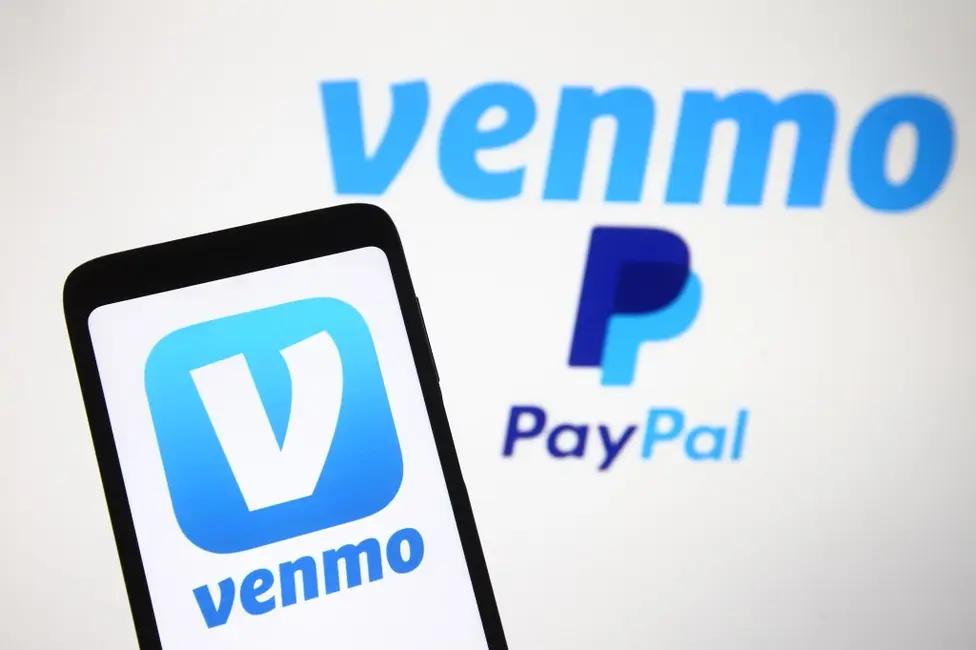 لوگوی Venmo، سرویس پرداخت موبایلی PayPal که بر روی یک گوشی هوشمند و صفحهنمایش کامپیوتر نمایش داده شده است.