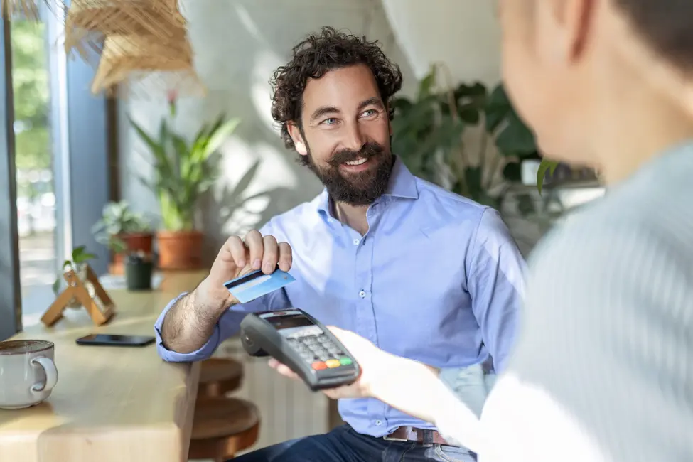 مردی که کارت اعتباری خود را برای پرداخت روی دستگاه میکوبد