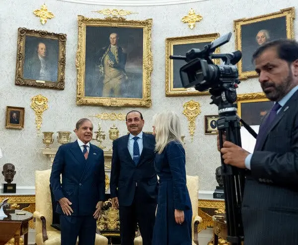 نخستوزیر شیهباز شریف (چپ) و مارشال اسیم مُنیر در حال ایستادن و گفتگو با زنی در یک اتاق رسمی با تزئینات طلایی و پرترههای دیواری