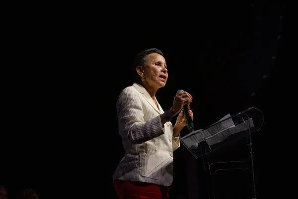 نماینده نیدیا ولاسکز، با کتوشلوار سفید، در ایستگاه سخنرانی صحبت میکند.