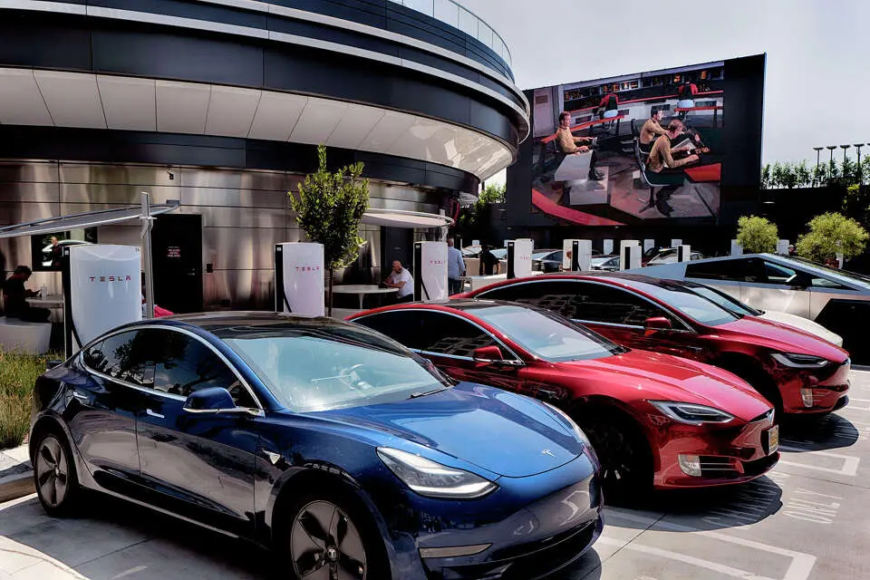 خودروهای برقی تسلا در ماه ژوئیه در پارکینگ «تسلا داینر» در محله هالیوود لسآنجلس صف کشیدهاند. مدیرعامل، ایلان ماسک، به مکانی در آستین اشاره میکند.