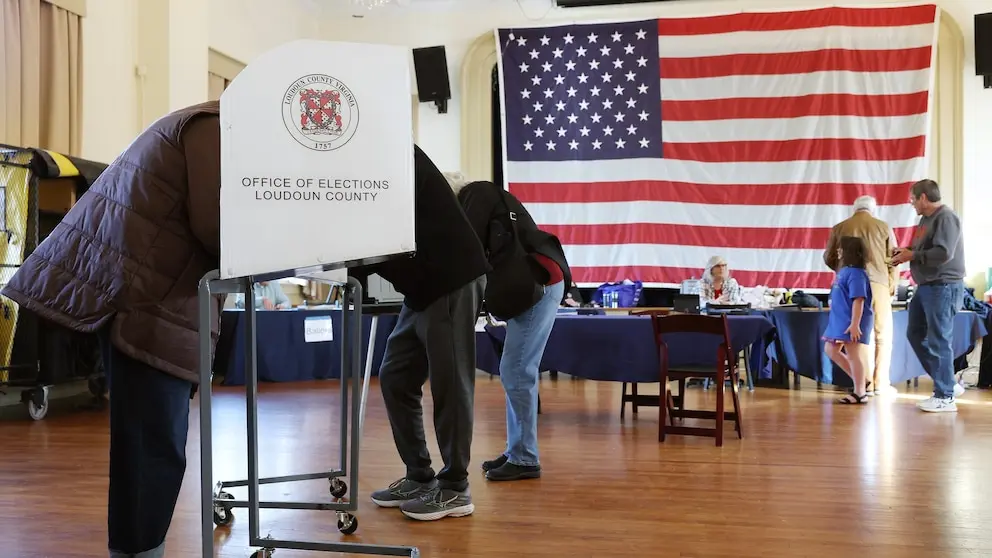 رأیدهندگان در حال پر کردن برگههای رأی خود در یک حوزه انتخاباتی در ویرجینیا.