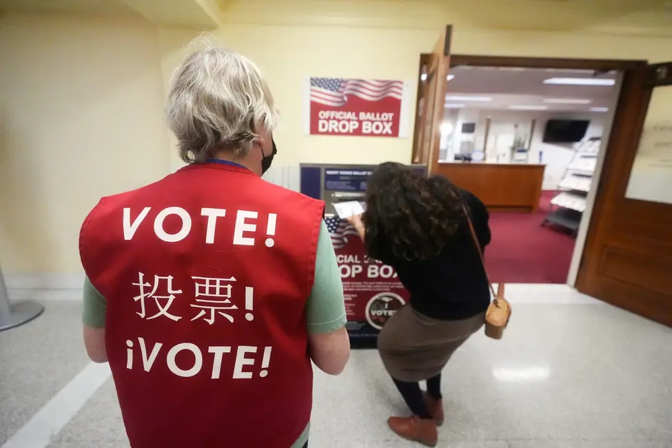 یک رأیدهنده در حال انداختن برگه رأی خود به صندوق در تالار شهر سانفرانسیسکو، کالیفرنیا.