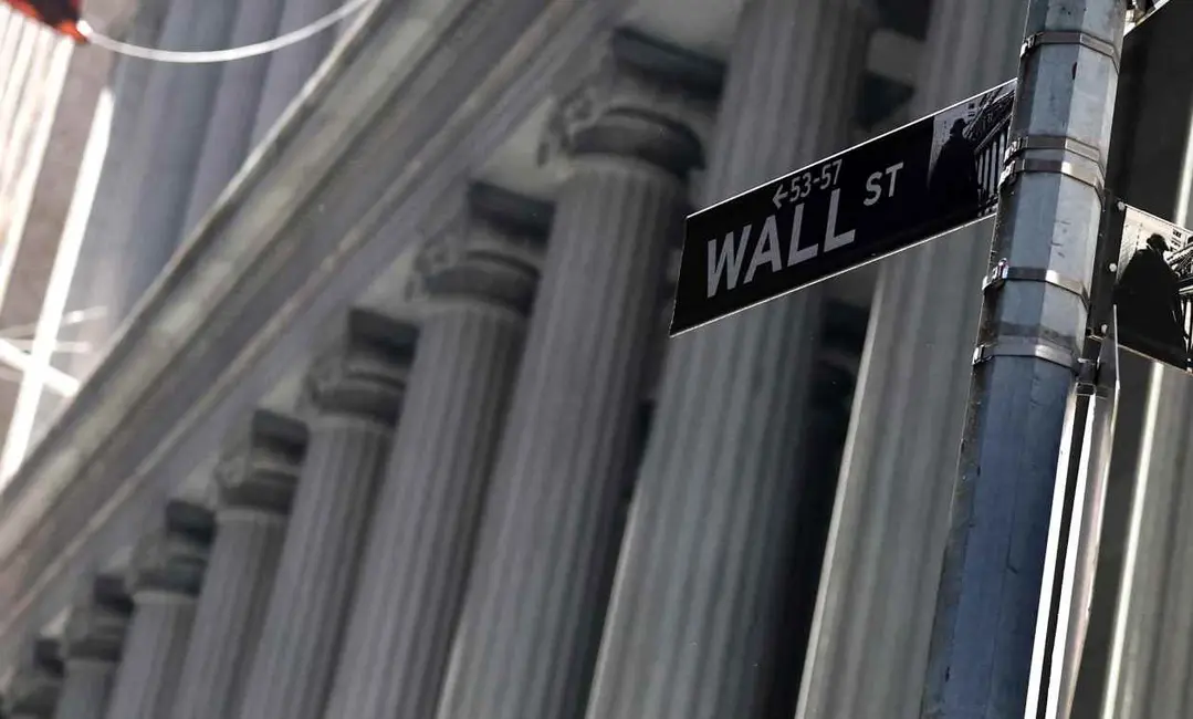 تابلوی خیابان «وال استریت» با فلش‌هایی به سمت چپ که به اعداد «۵۳-۵۷» اشاره می‌کنند، در پس‌زمینه‌ای از ستون‌های نئوکلاسیک.