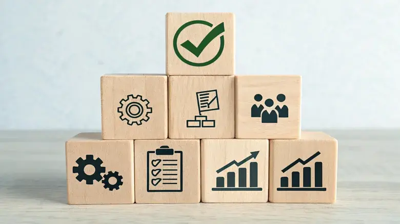 بلوک‌های چوبی با آیکون‌های کاری که به شکل هرم روی میز چیده شده‌اند