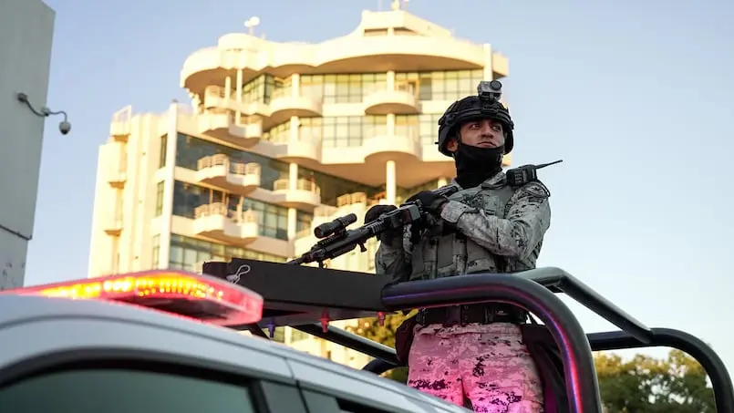 سرباز گارد ملی در پارکینگ یک مرکز خرید در کولیاکان، سینالوآ، در تاریخ ۱۳ دسامبر به‌دقت مراقبت می‌کند.