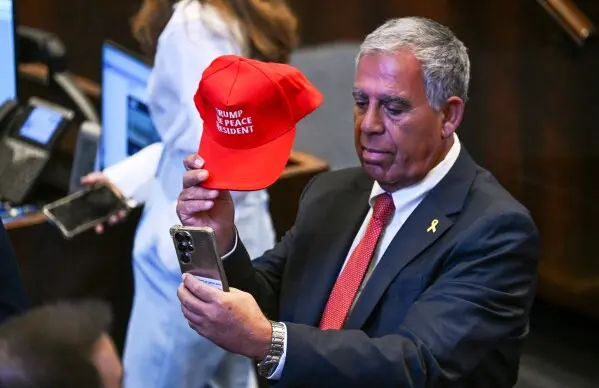 افرادی که کلاههایی با نوشتار «ترامپ، رئیسجمهور صلح» در کنیست میپوشند، در حالی که رئیسجمهور دونالد ترامپ برای ایراد سخنرانی در ۱۳ اکتبر ۲۰۲۵ در اورشلیم آماده میشود. (کنی هولستون/نیویورک تایمز از طریق AP، Pool)