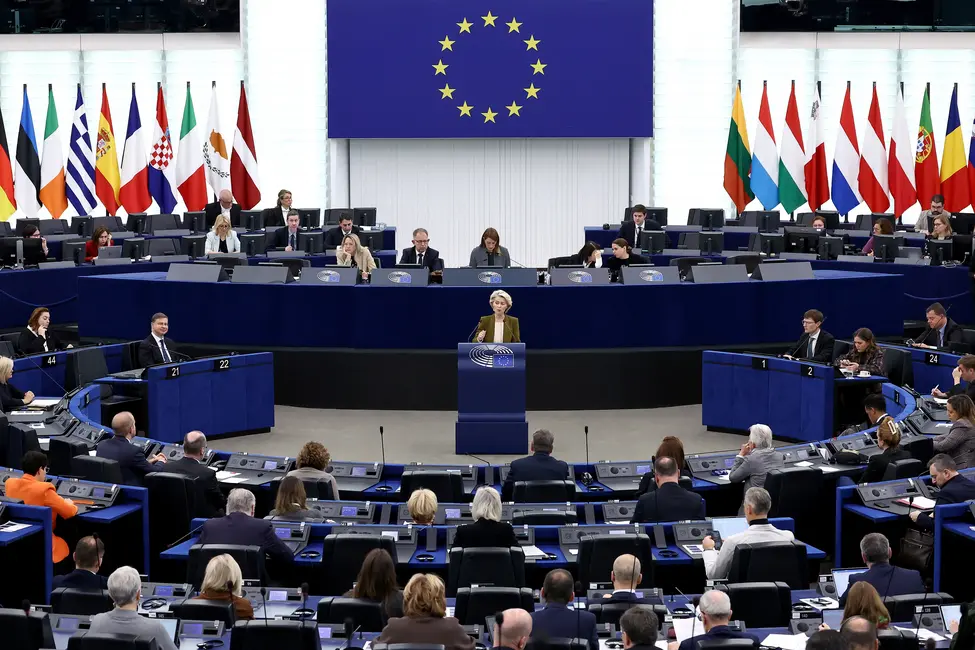جلسه‌ای از پارلمان اروپا در حال برگزاری، نمایندگان نشسته‌اند. پرچم اتحادیه اروپا به‌وضوح در جلو نمایش داده می‌شود