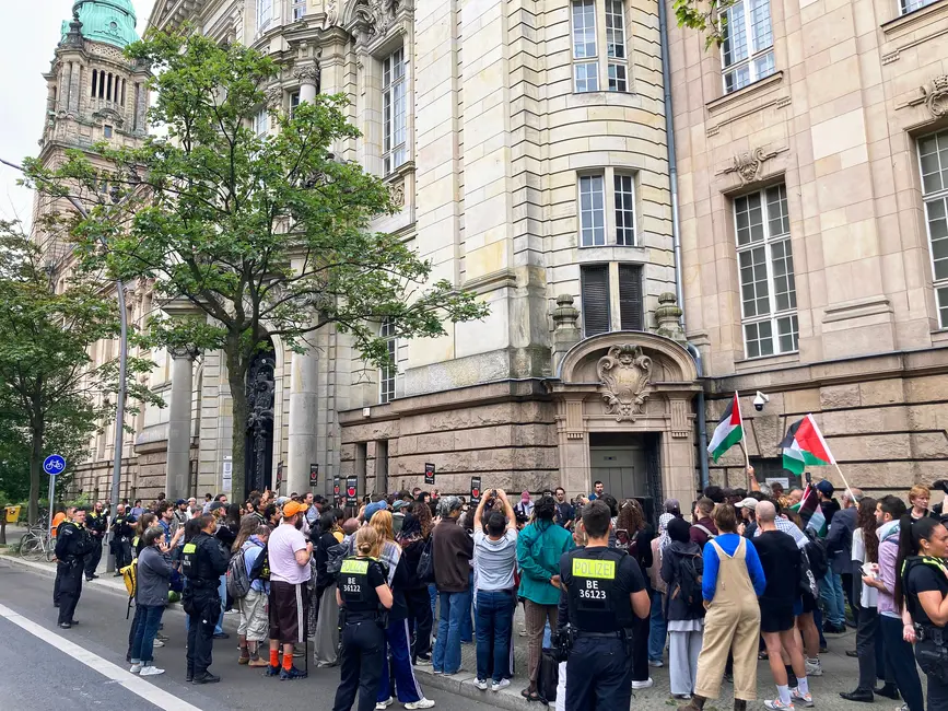 جمعیتی خارج از یک بنای تاریخی، برخی پرچم فلسطین در دست دارند، پلیس‌ها صحنه را نظارت می‌کنند