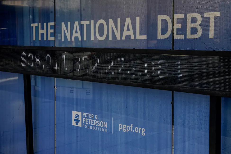 سقفی ایستگاه اتوبوس همراه با بیلبورد الکترونیکی و پوستر که بدهی فعلی ایالات متحده را در تاریخ ۲۸ اکتبر ۲۰۲۵ در واشنگتن، دی.سی. نمایش میدهد.